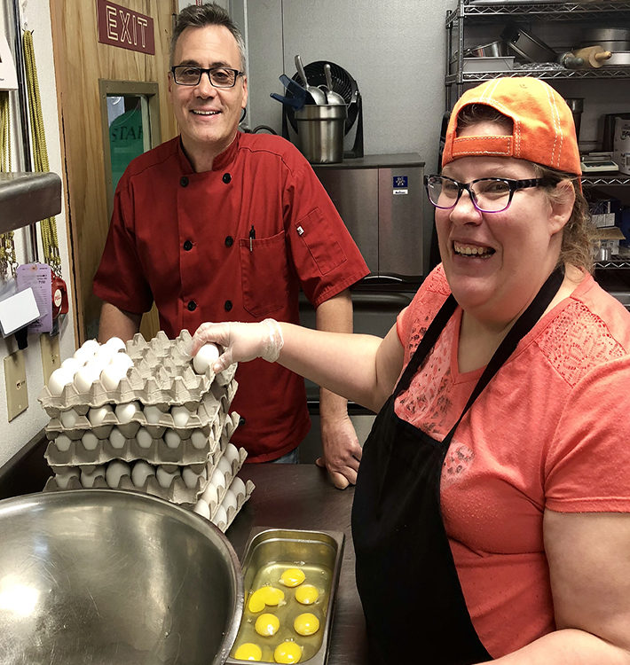 Chef Philip and Liz stand with eggs in the kitchen.