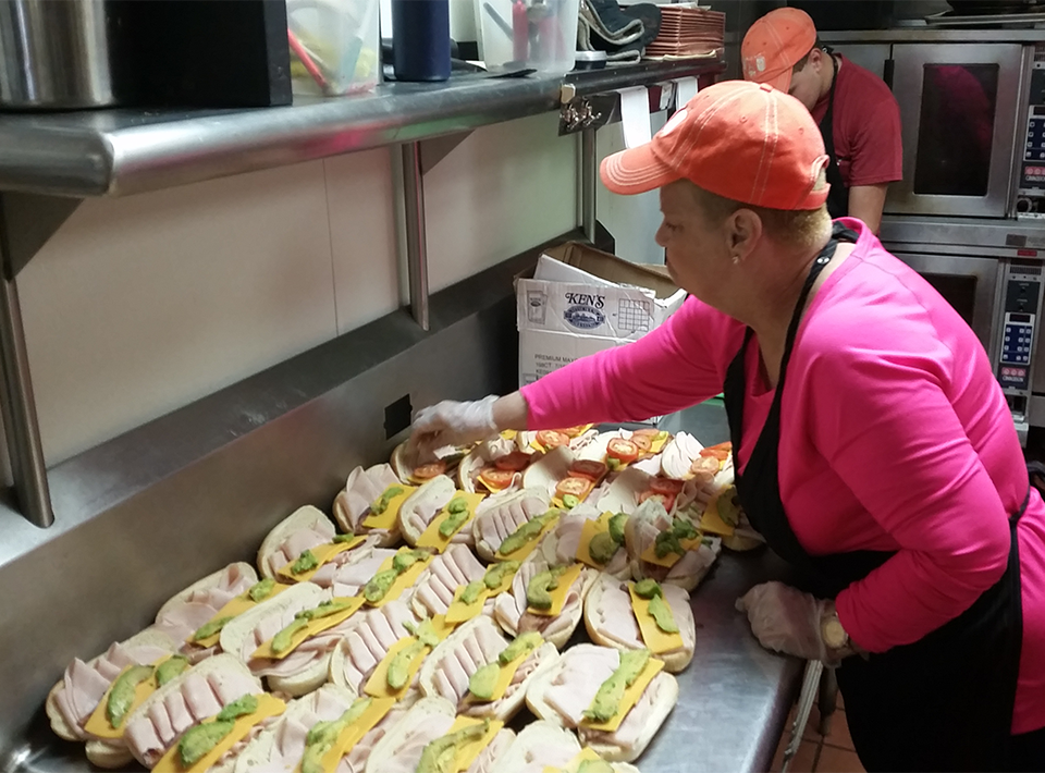 Civitan Foundation member works in kitchen preparing sandwiches.